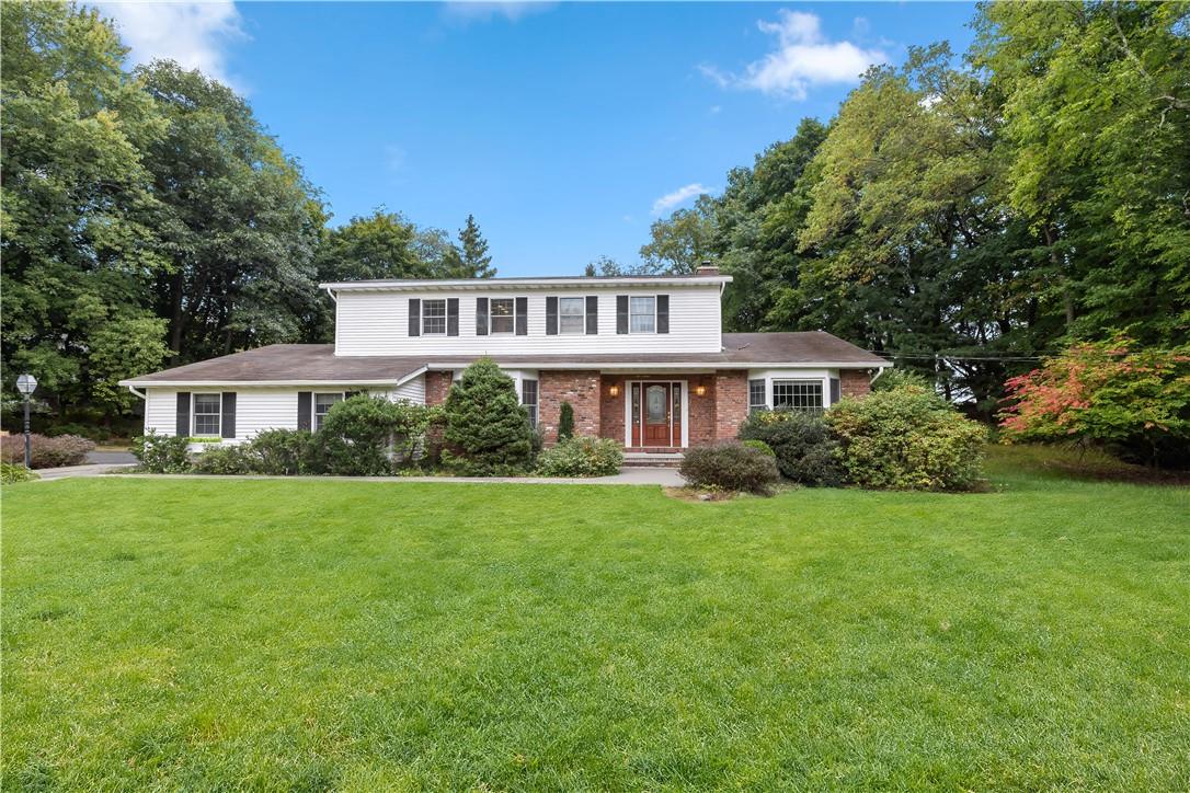 a front view of a house with a yard and trees