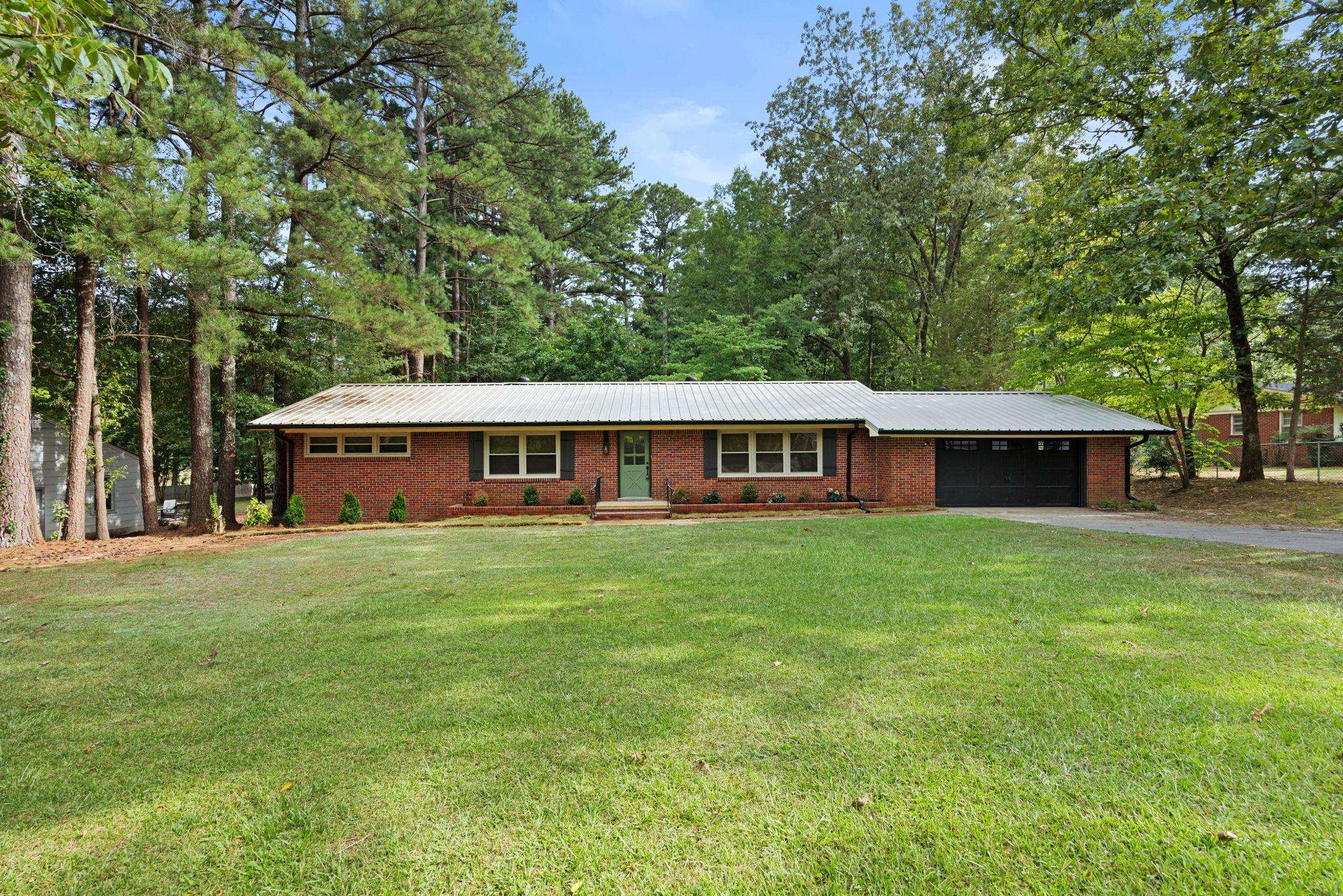 Single story home featuring a garage and a front yard