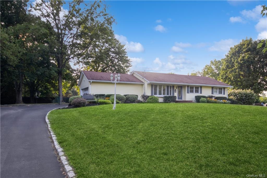 a view of a house with a big yard plants and large trees