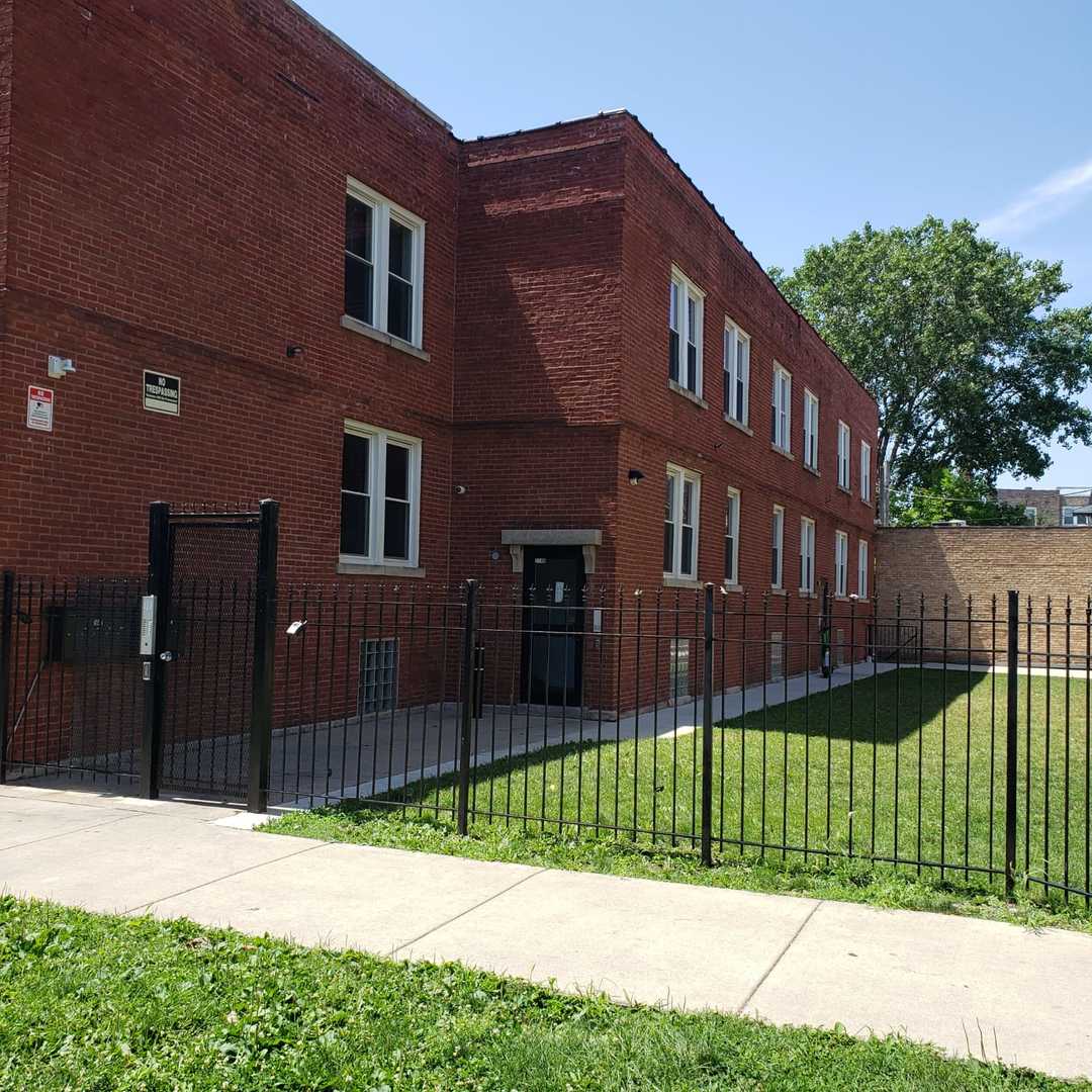 a view of a brick house in front of a yard