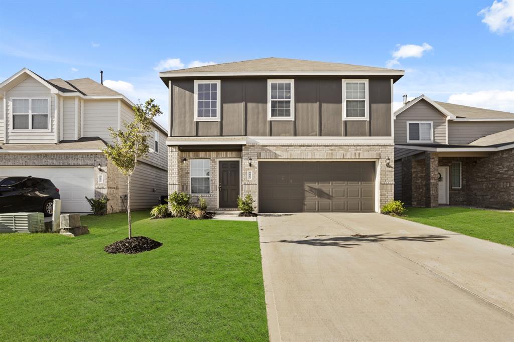 a front view of a house with a yard and garage