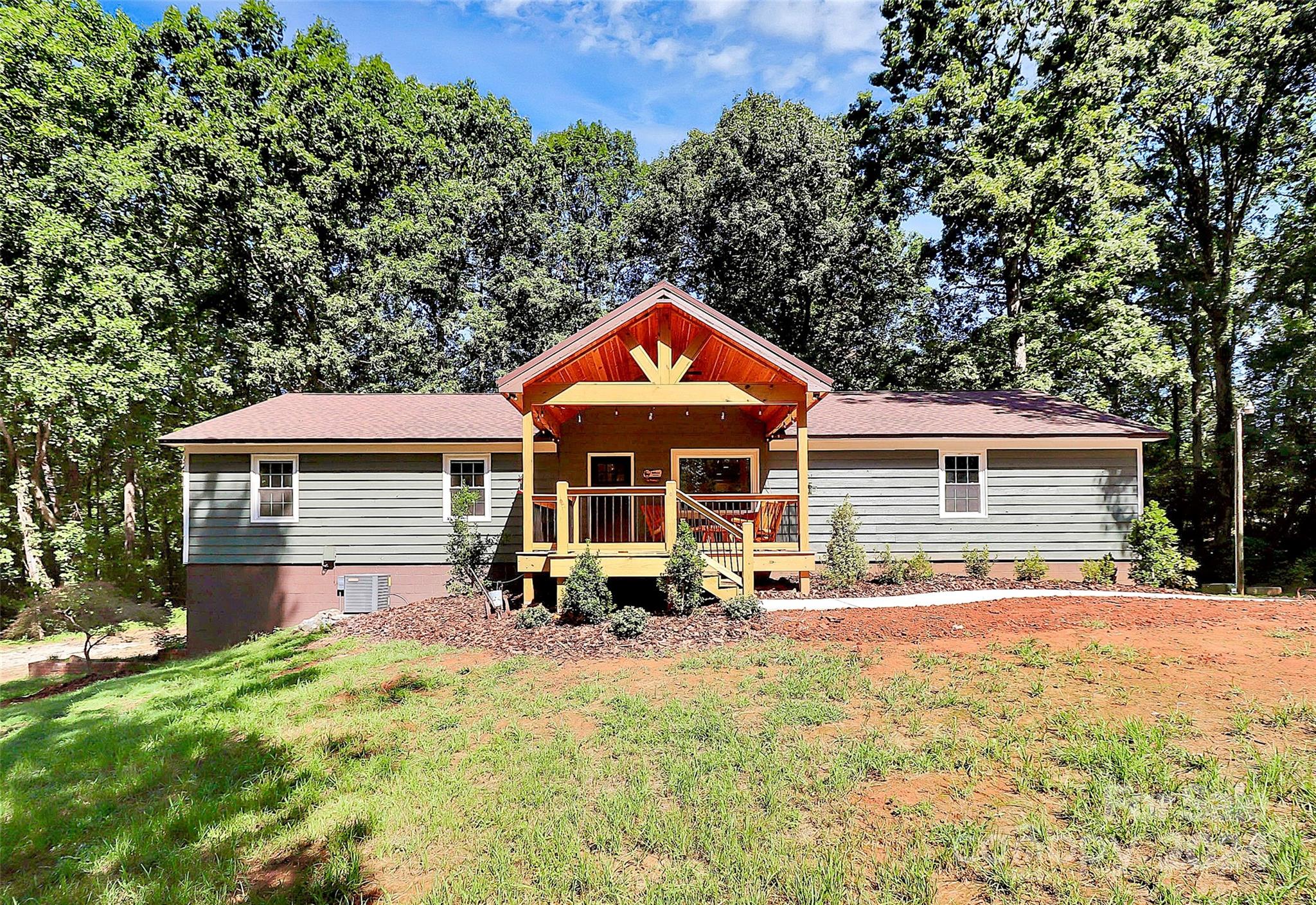 a front view of house with yard and trees in the background