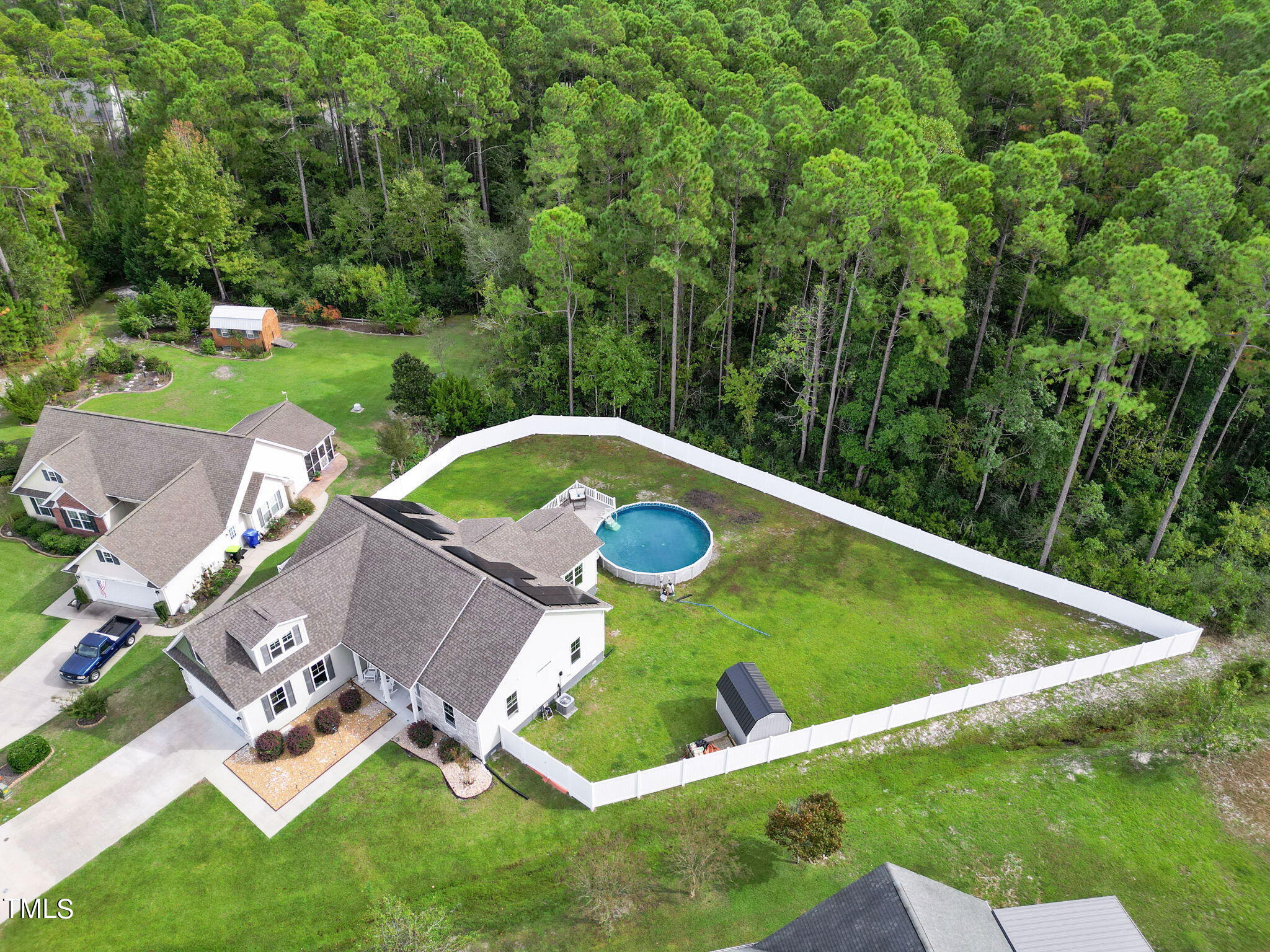 an aerial view of a house with pool and trees