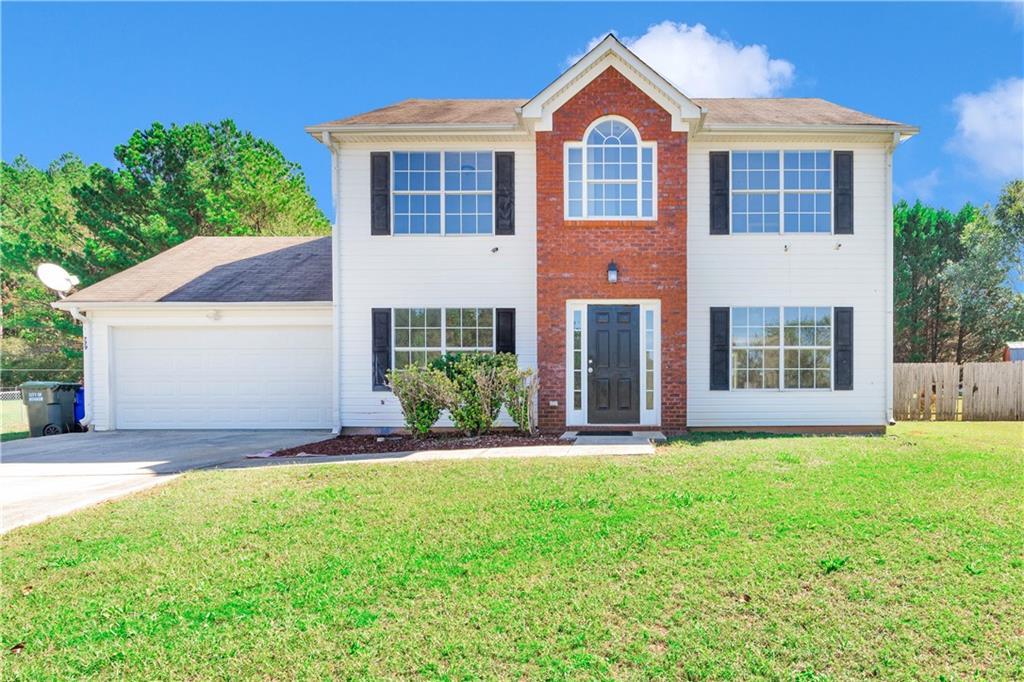 a front view of a house with a yard and garage