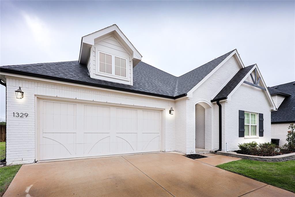 a front view of a house with a garden and garage