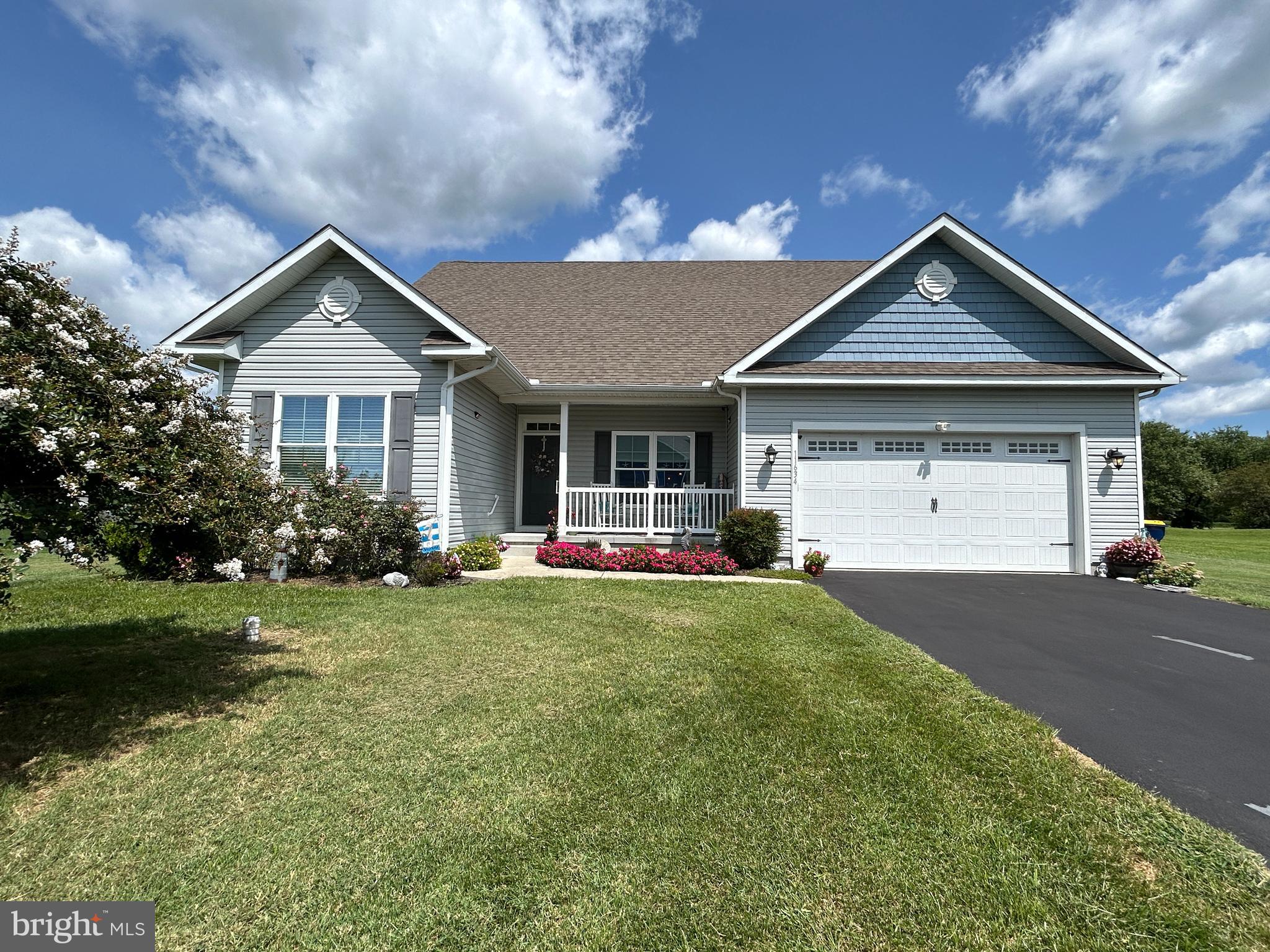 a front view of a house with yard and green space