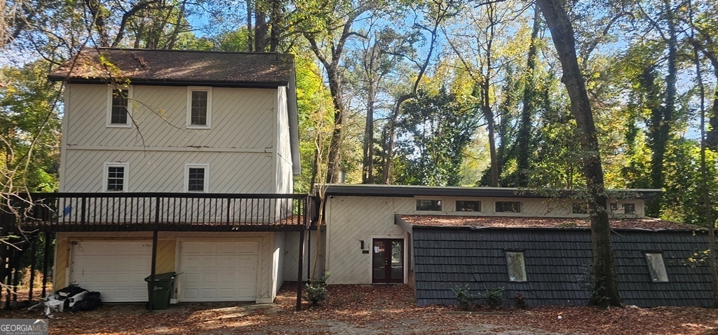 a view of a house with a fence and a tree