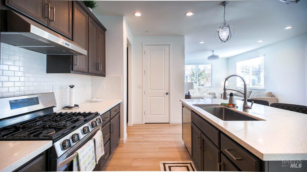 a kitchen with kitchen island stainless steel appliances a sink stove and cabinets