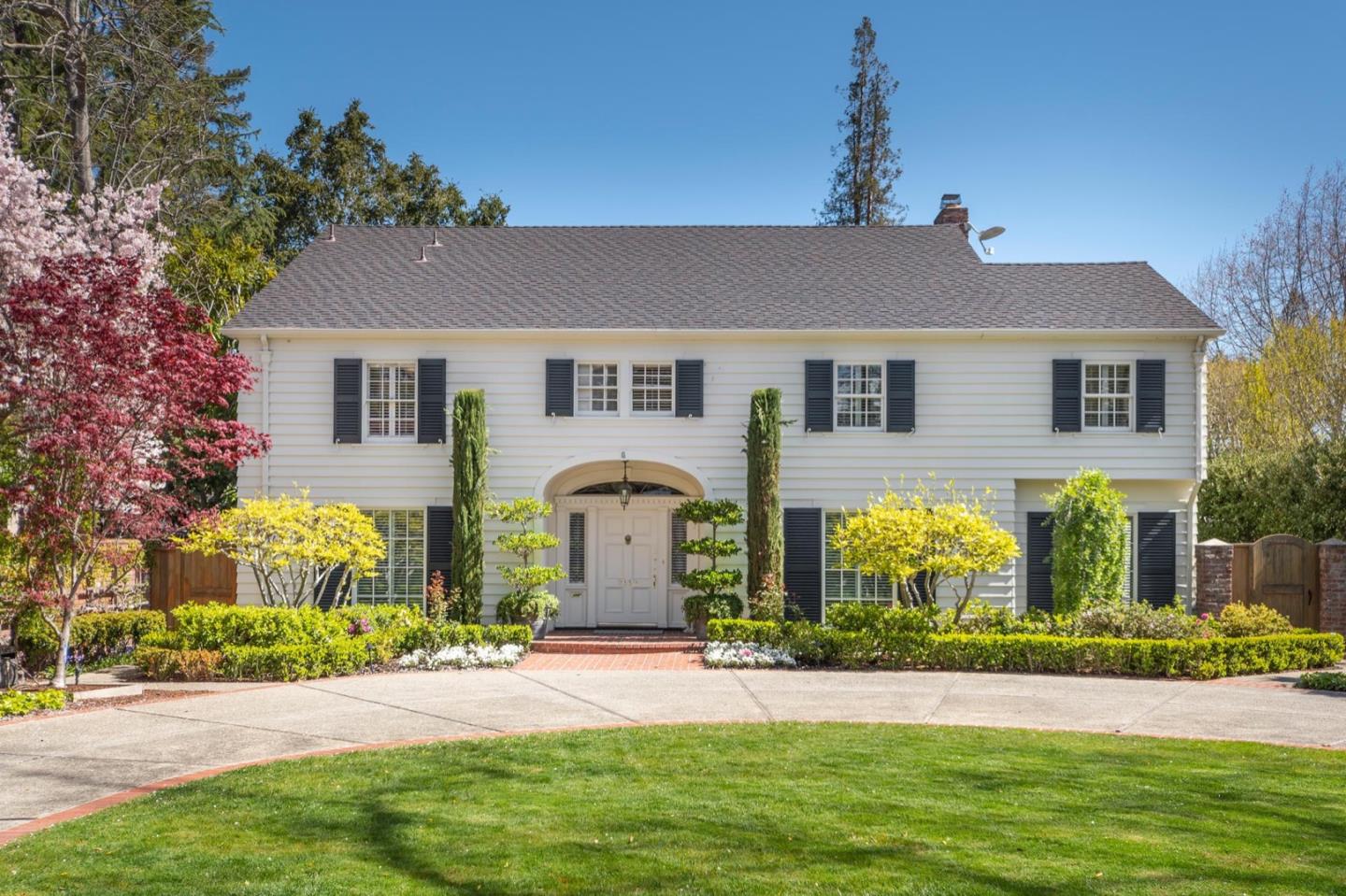 a front view of yellow house with a yard