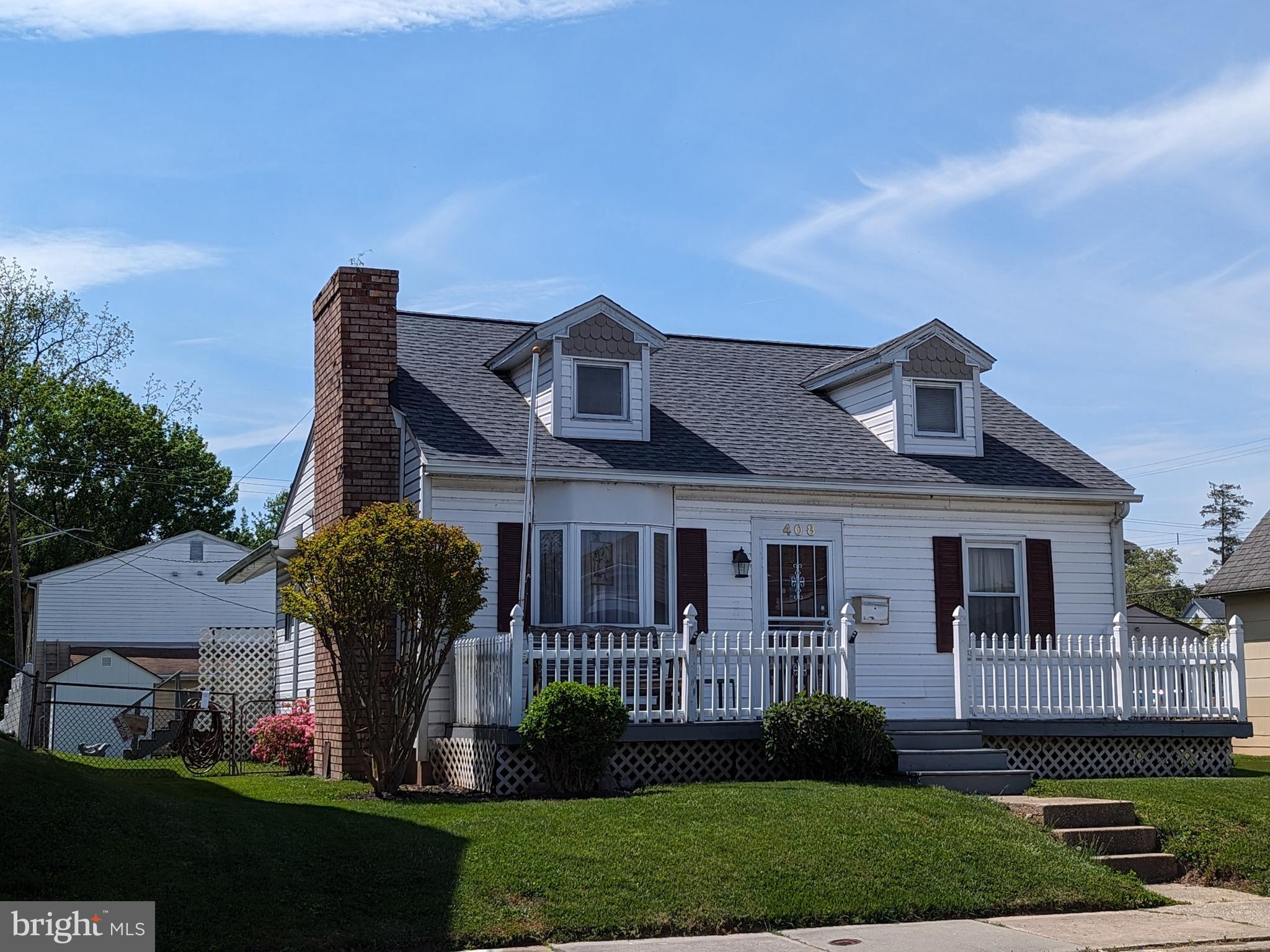 a front view of a house with a garden and plants