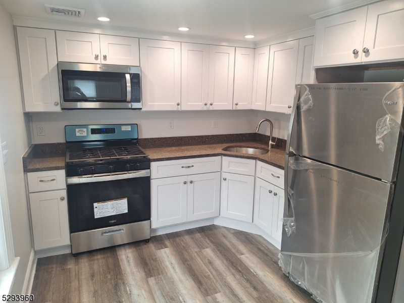 a kitchen with white cabinets stainless steel appliances and sink