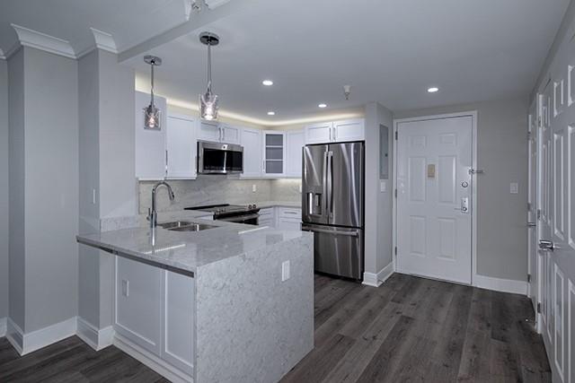 a kitchen with kitchen island a sink stainless steel appliances and refrigerator