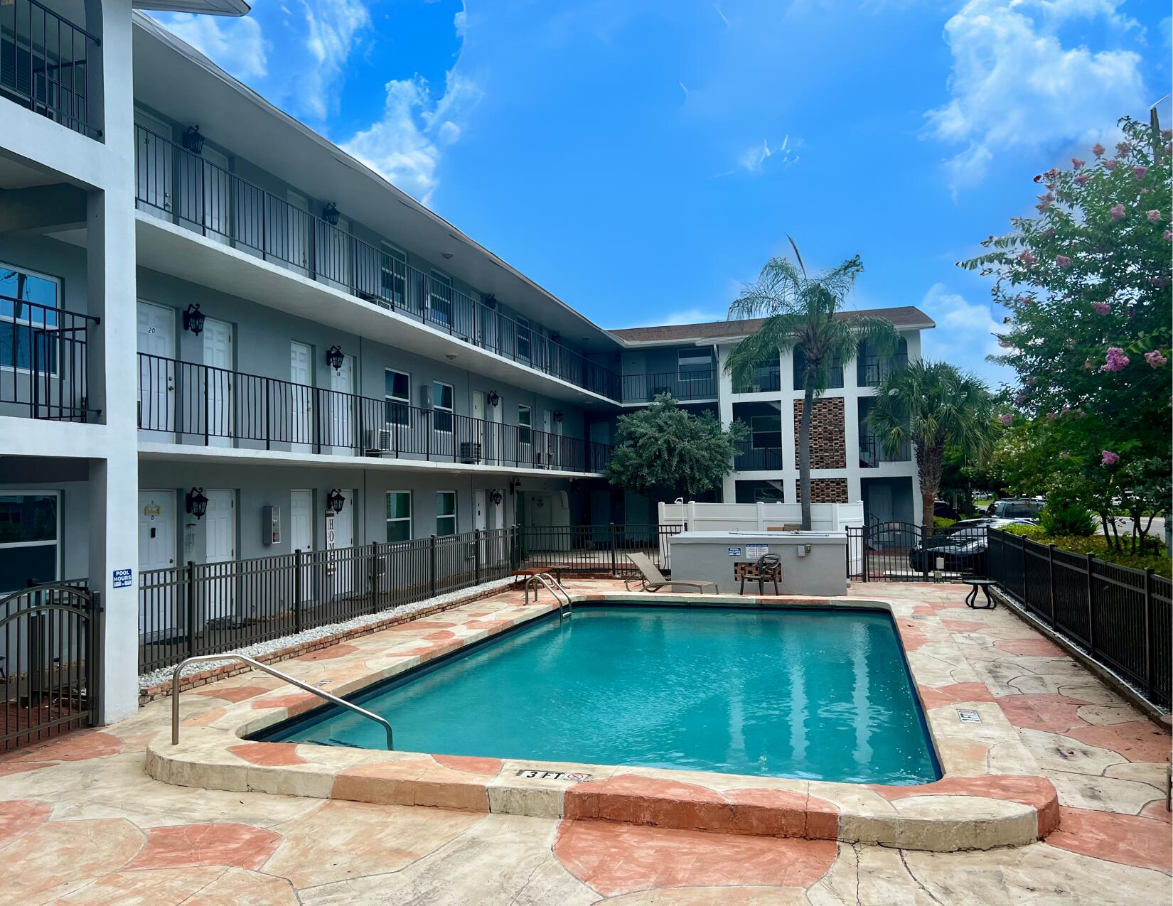 a view of a swimming pool with a lounge chairs in front of a house