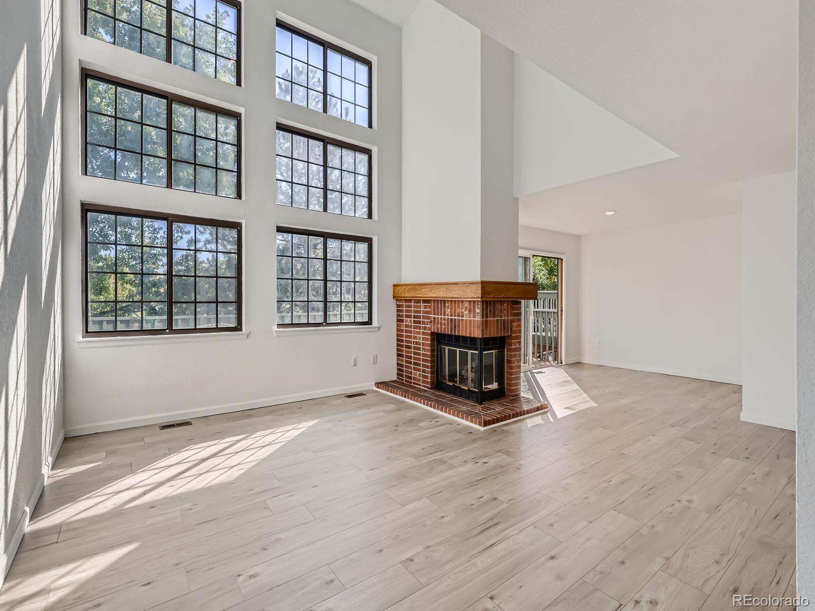 a view of an empty room with a fireplace and a window