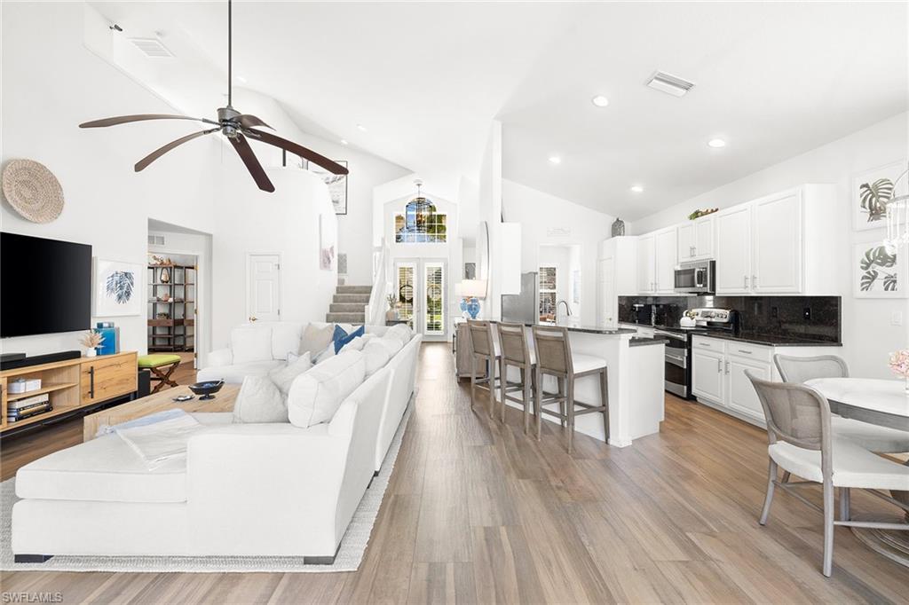 a living room with furniture a flat screen tv and kitchen view