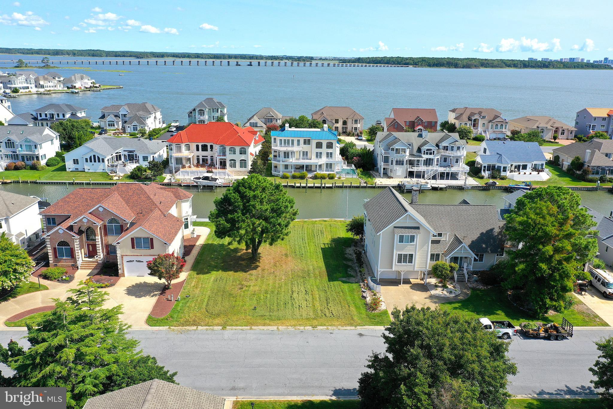 an aerial view of a house with lots of trees and ocean view