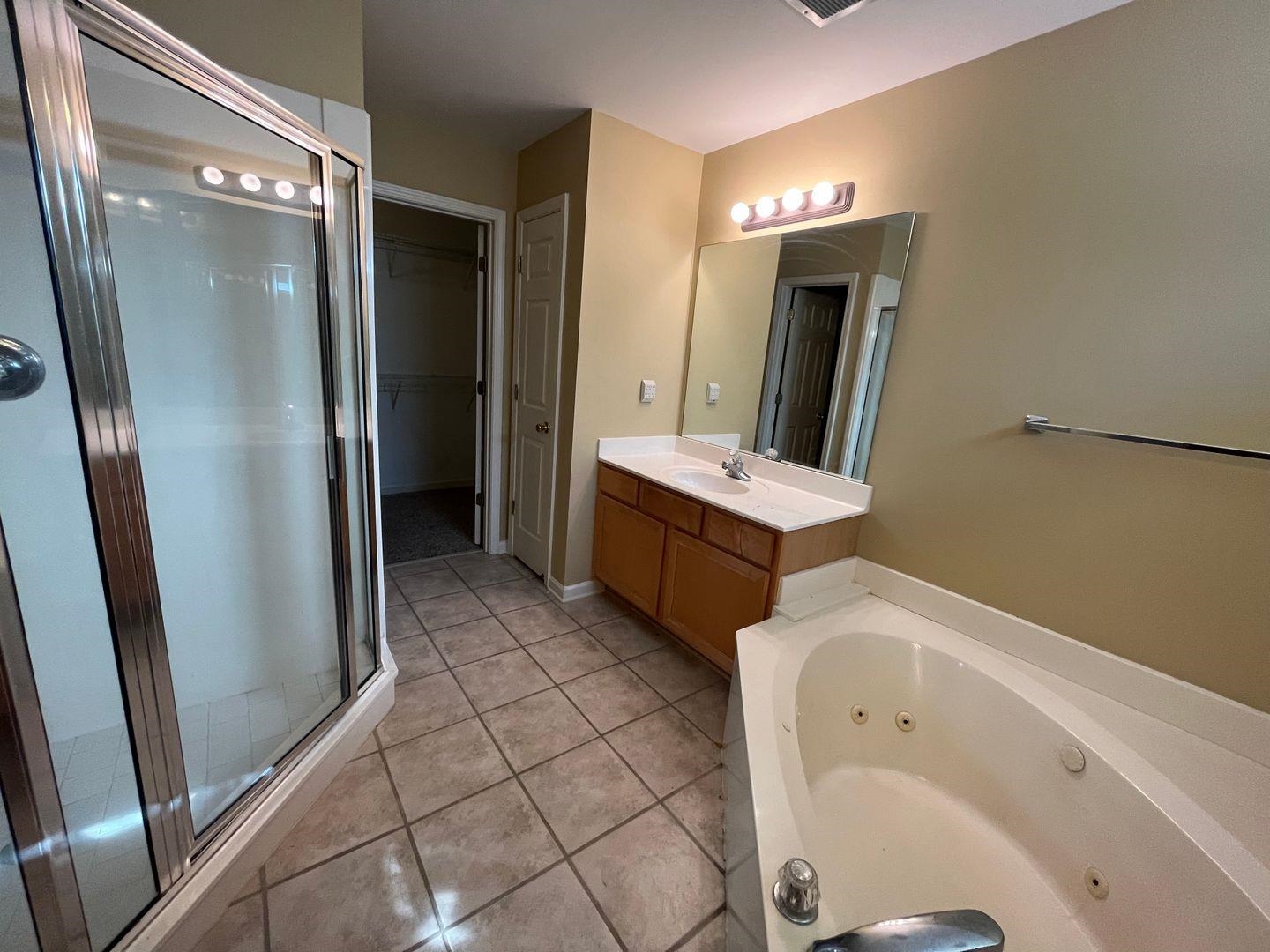 a bathroom with a tub sink and mirror