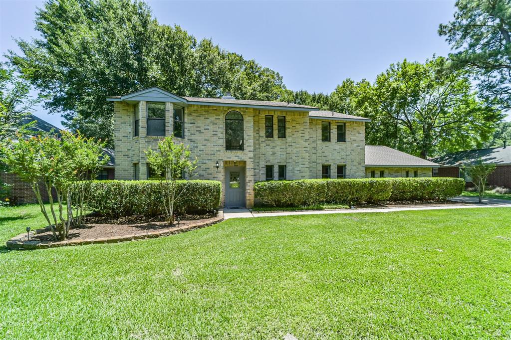 a front view of a house with a yard and green space