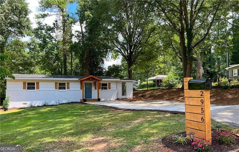 a front view of house with yard and trees around