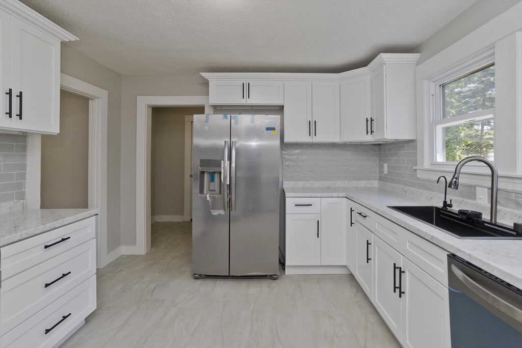 a kitchen with a refrigerator sink and cabinets