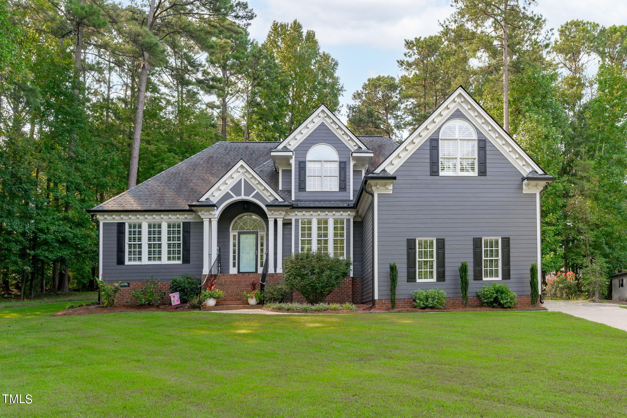 a front view of a house with a garden