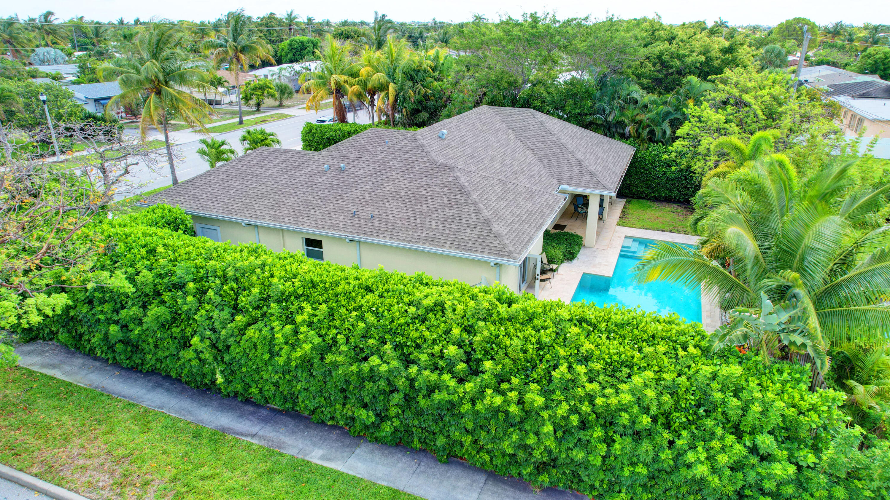 a aerial view of a house with yard and large trees