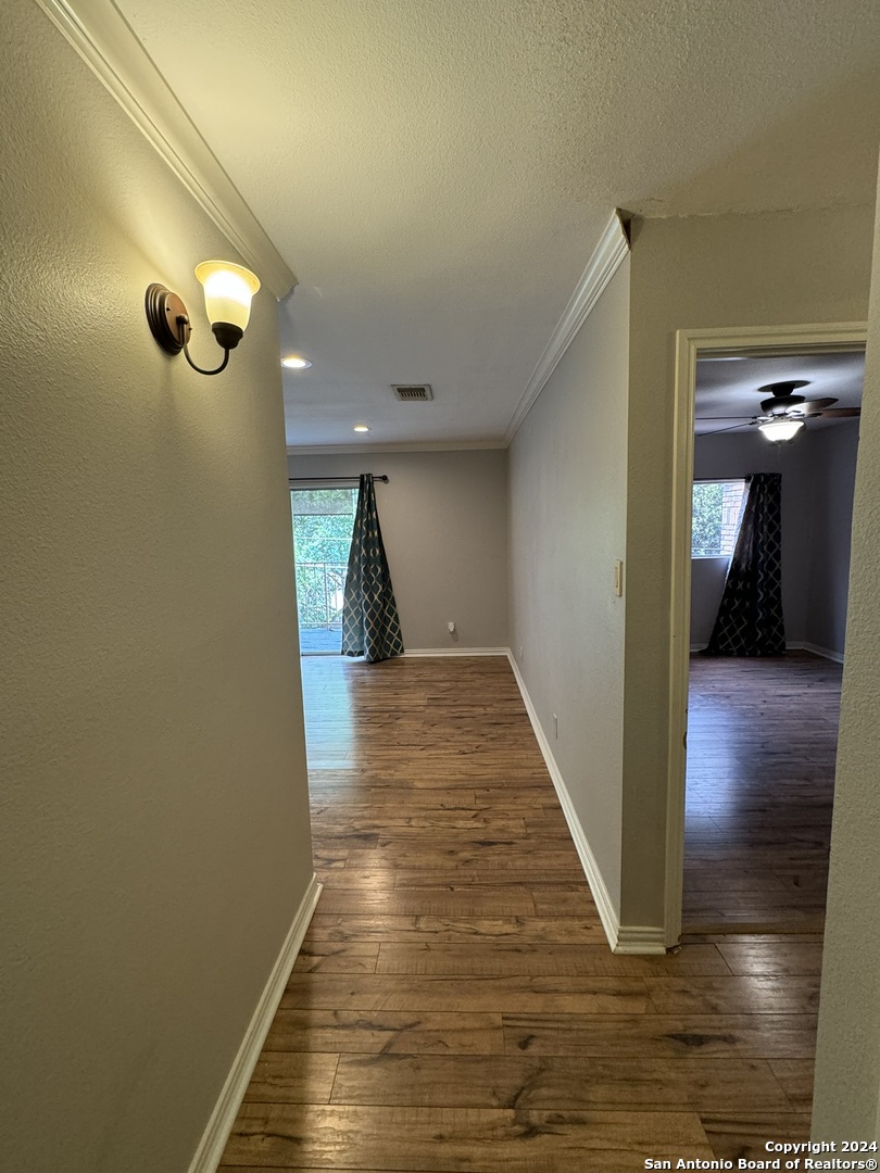 a view of a hallway with wooden floor