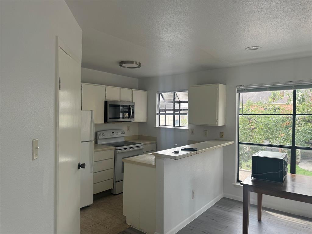 a view of a kitchen with a sink a fireplace and windows