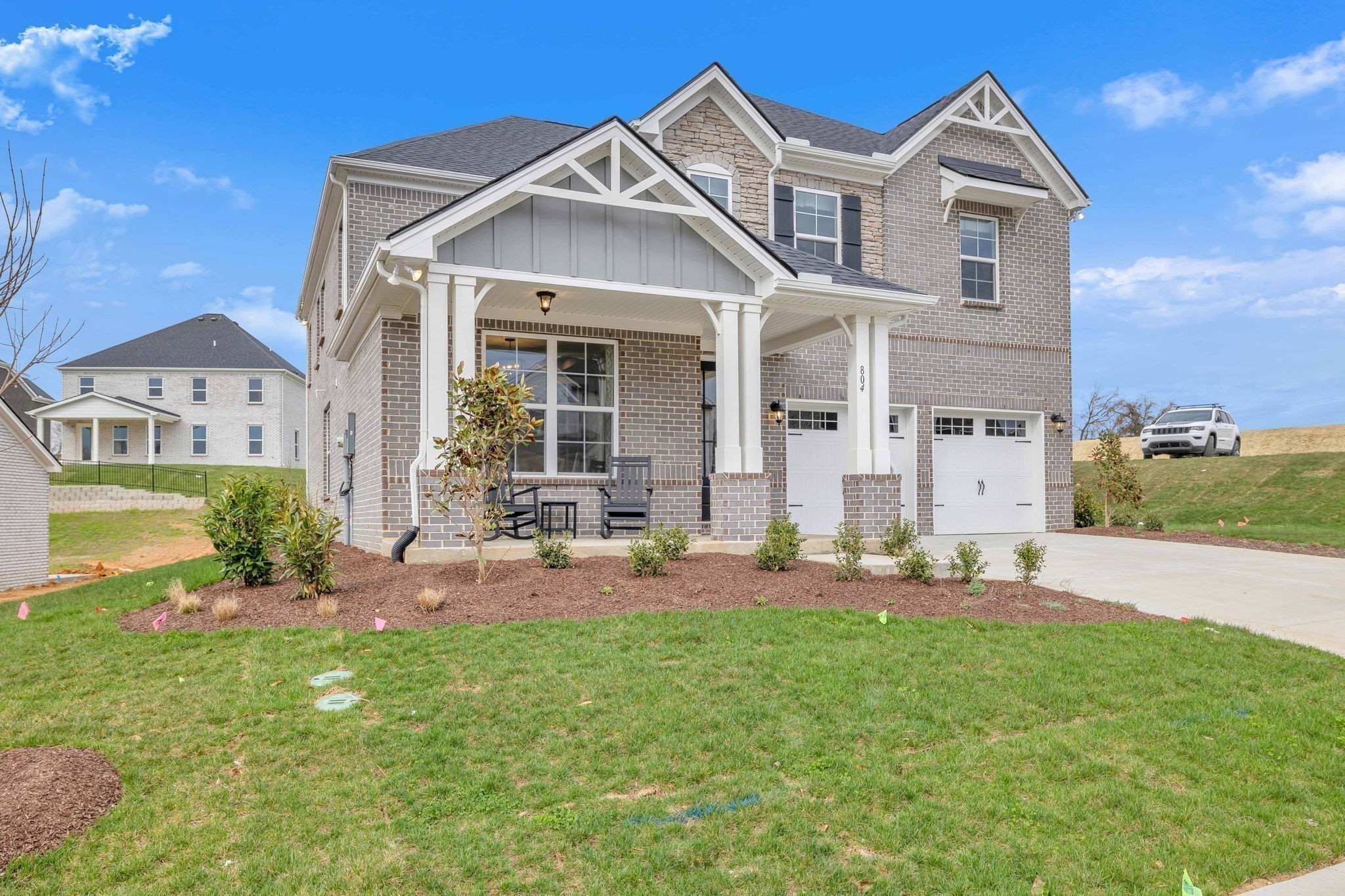 a front view of a house with a big yard and potted plants