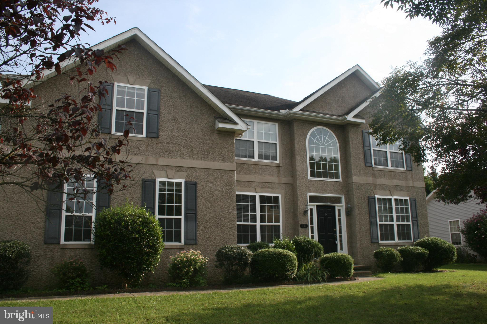 a front view of a house with a yard and trees