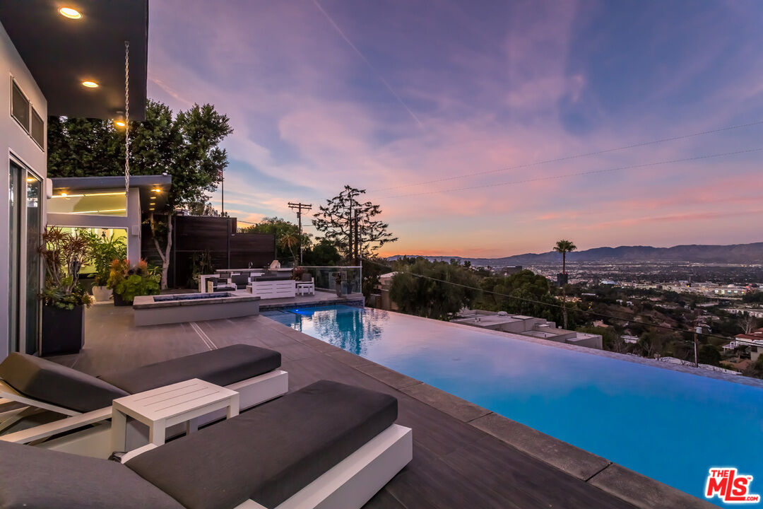 a view of swimming pool outdoor seating and city view