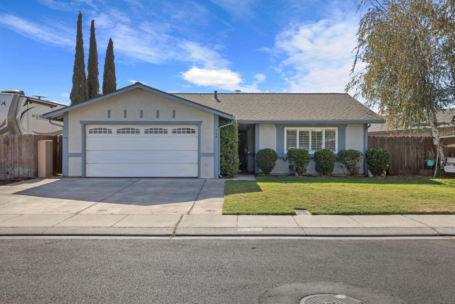 a front view of a house with a yard and trees