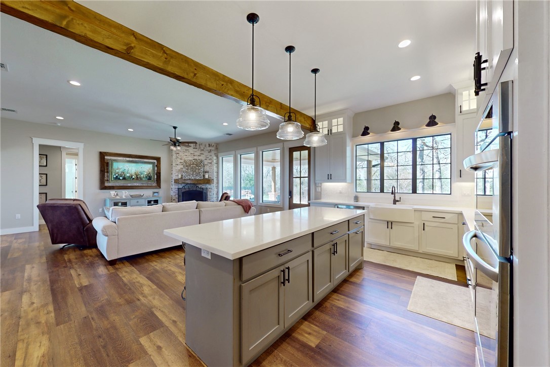 a large room with kitchen island a sink a counter space and stainless steel appliances