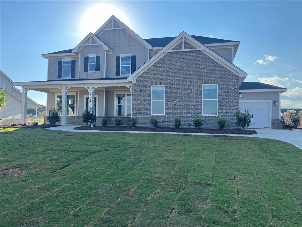 a front view of a house with a yard and potted plants