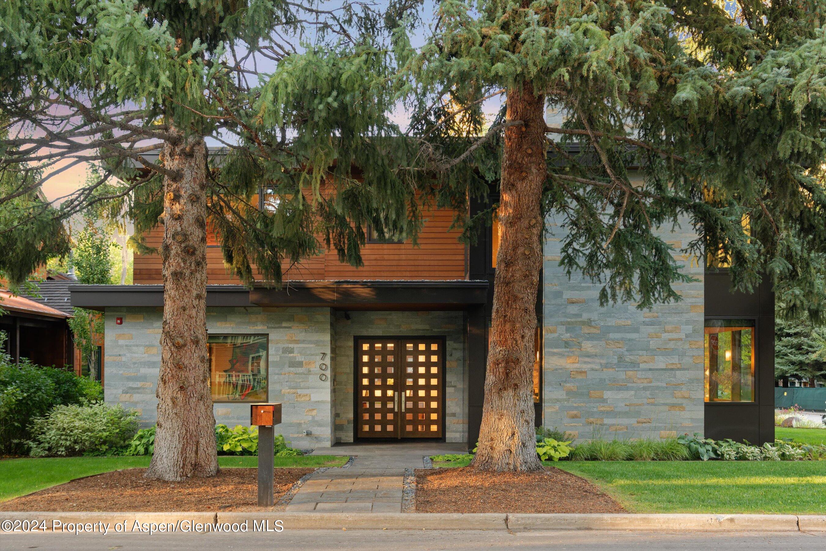 a front view of a house with a tree