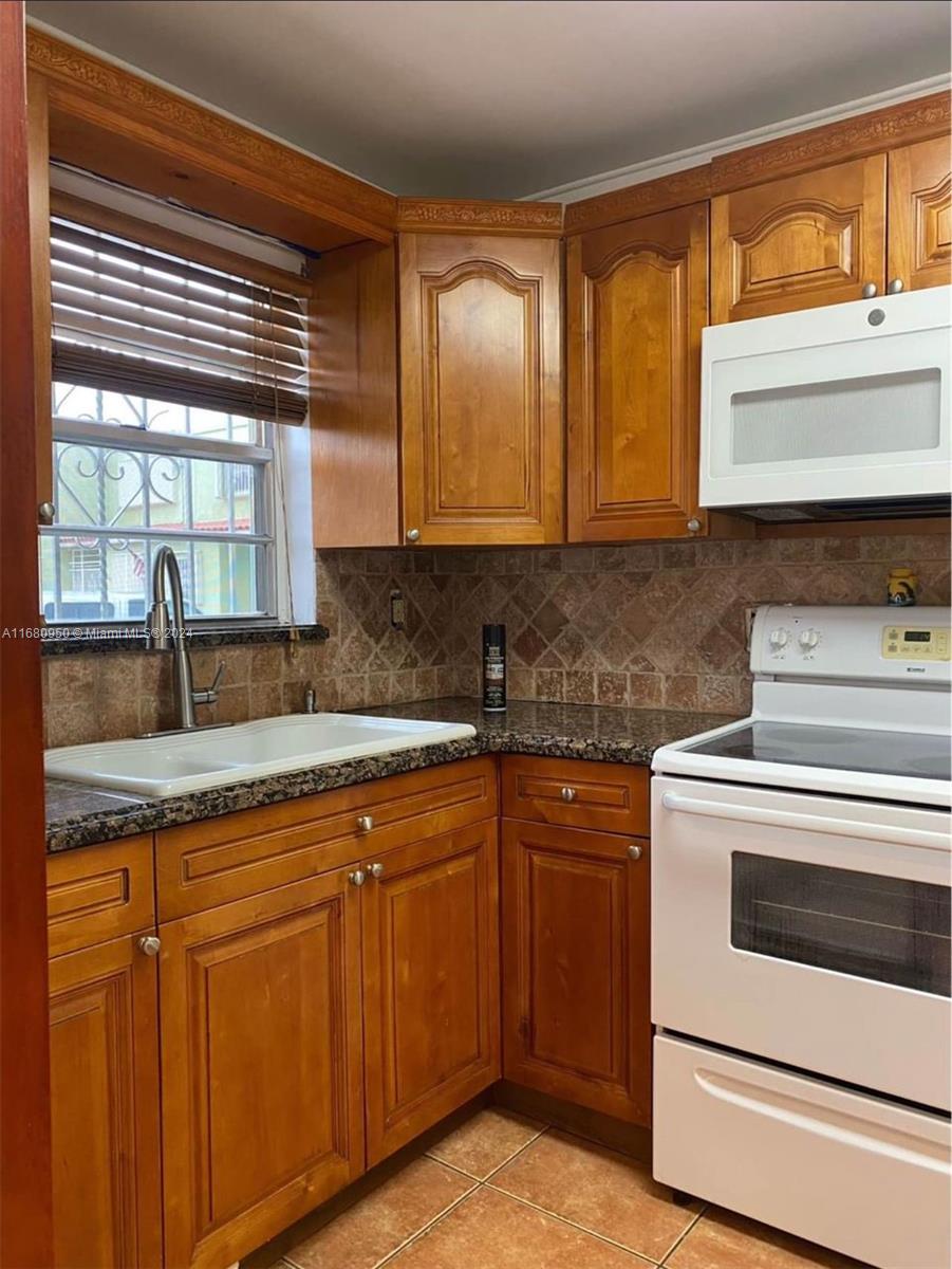 a kitchen with granite countertop cabinets stainless steel appliances and a sink