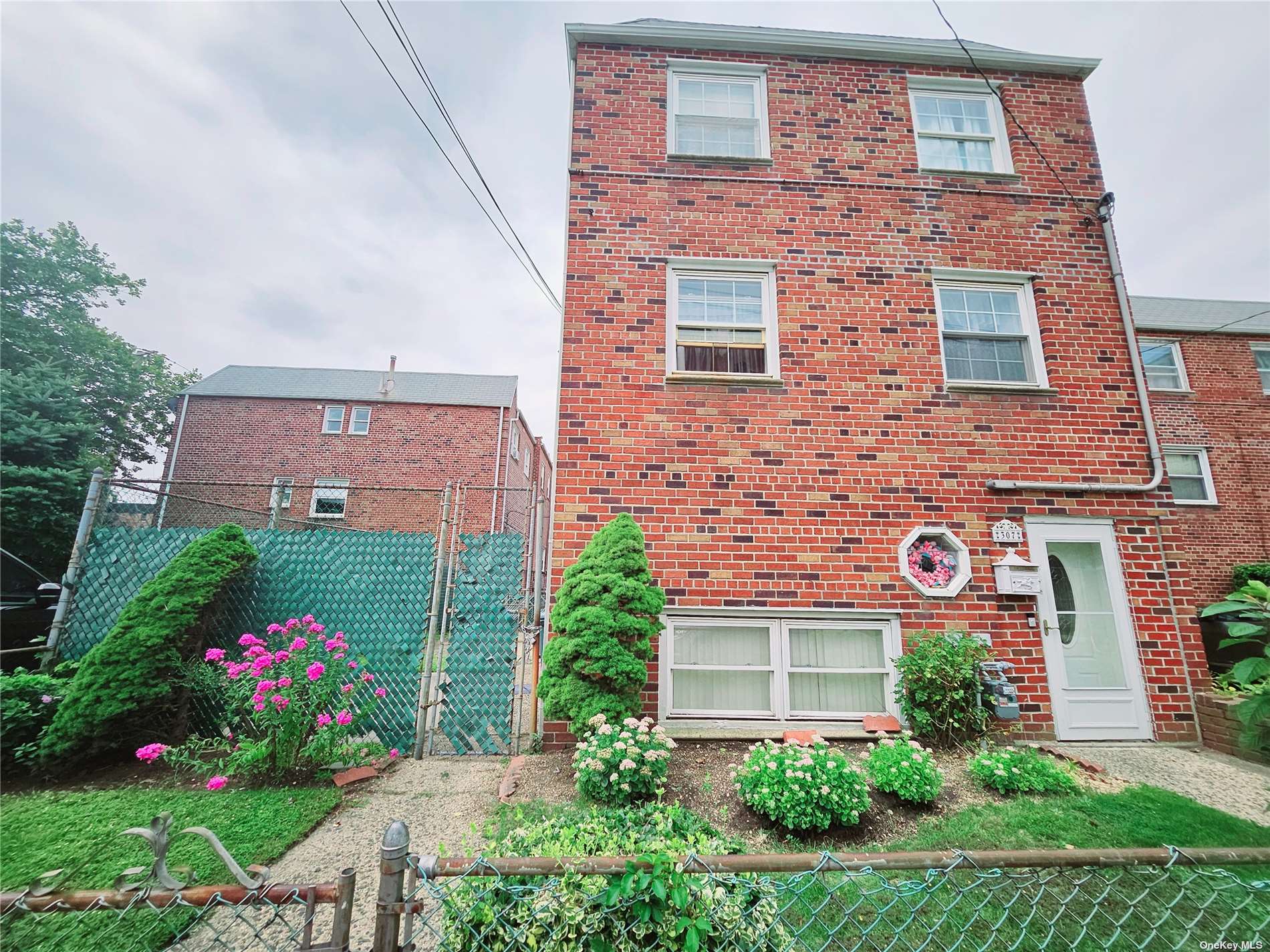 a view of a brick house with a yard and potted plants