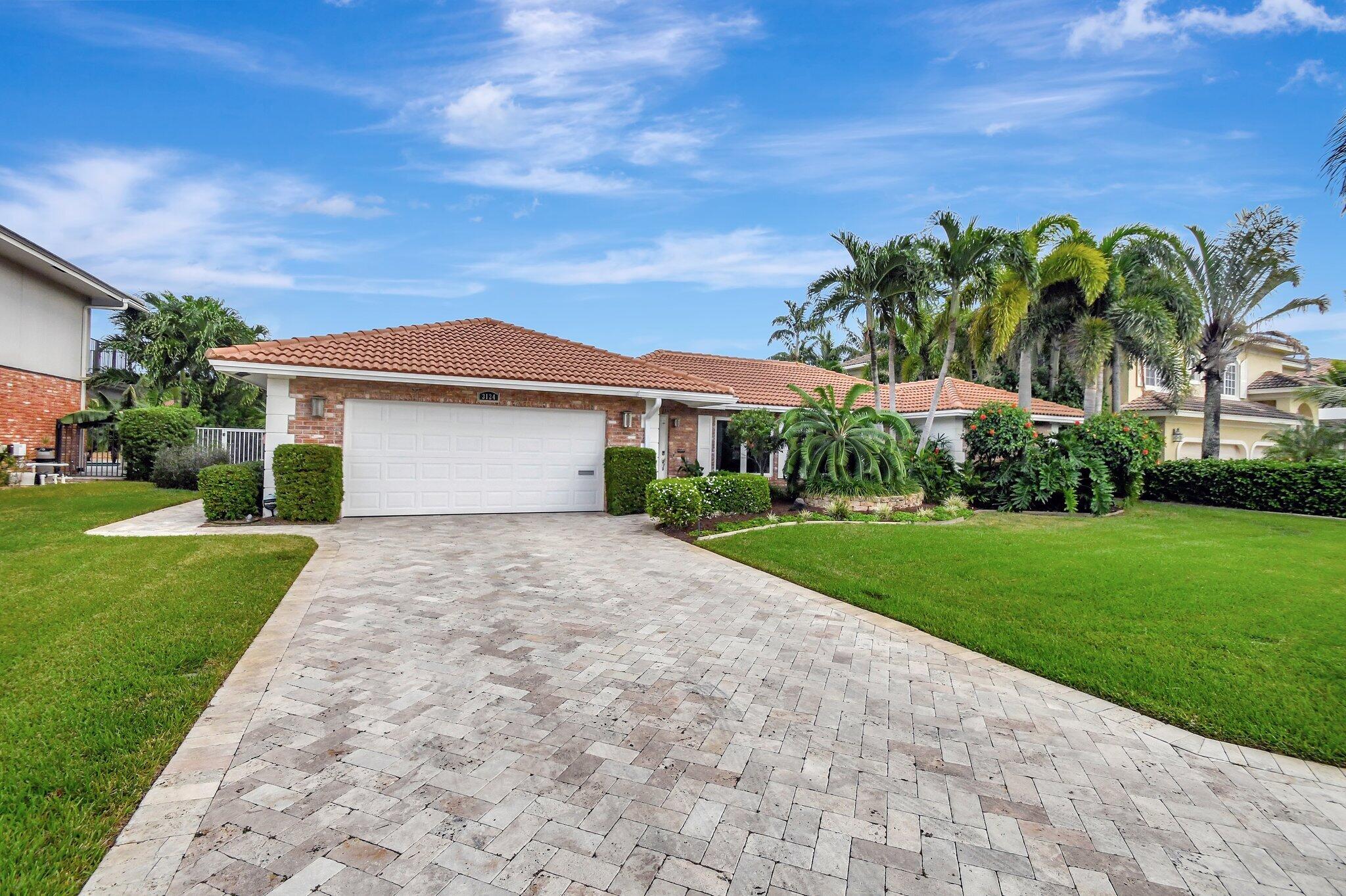 a front view of a house with a yard and palm tree