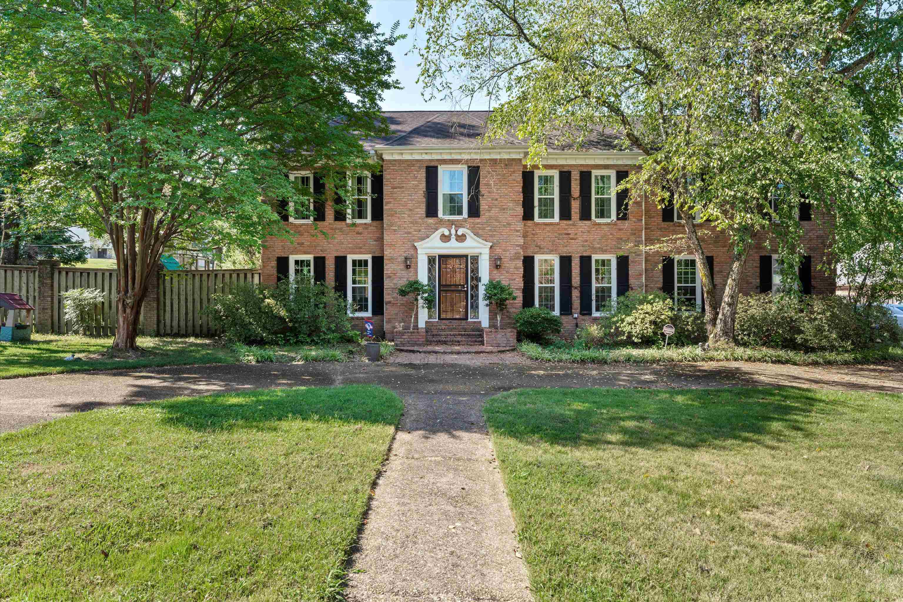 a front view of a house with yard and green space