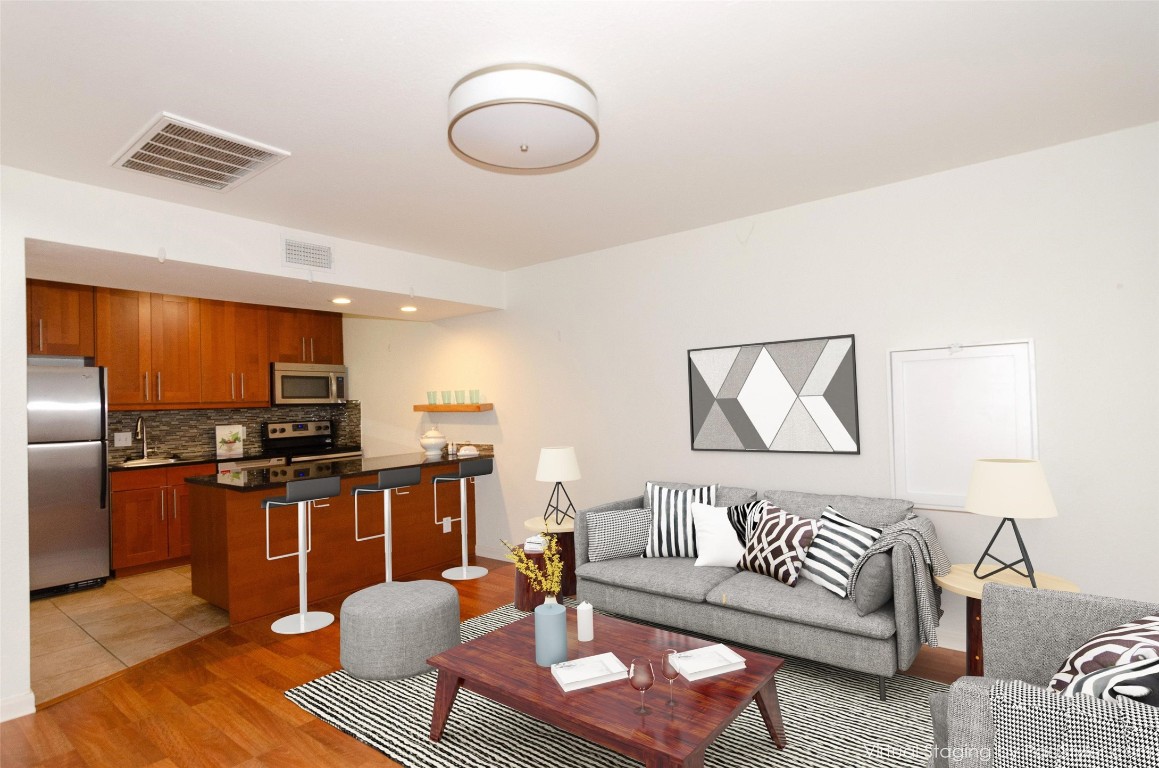 a living room with furniture kitchen and a table