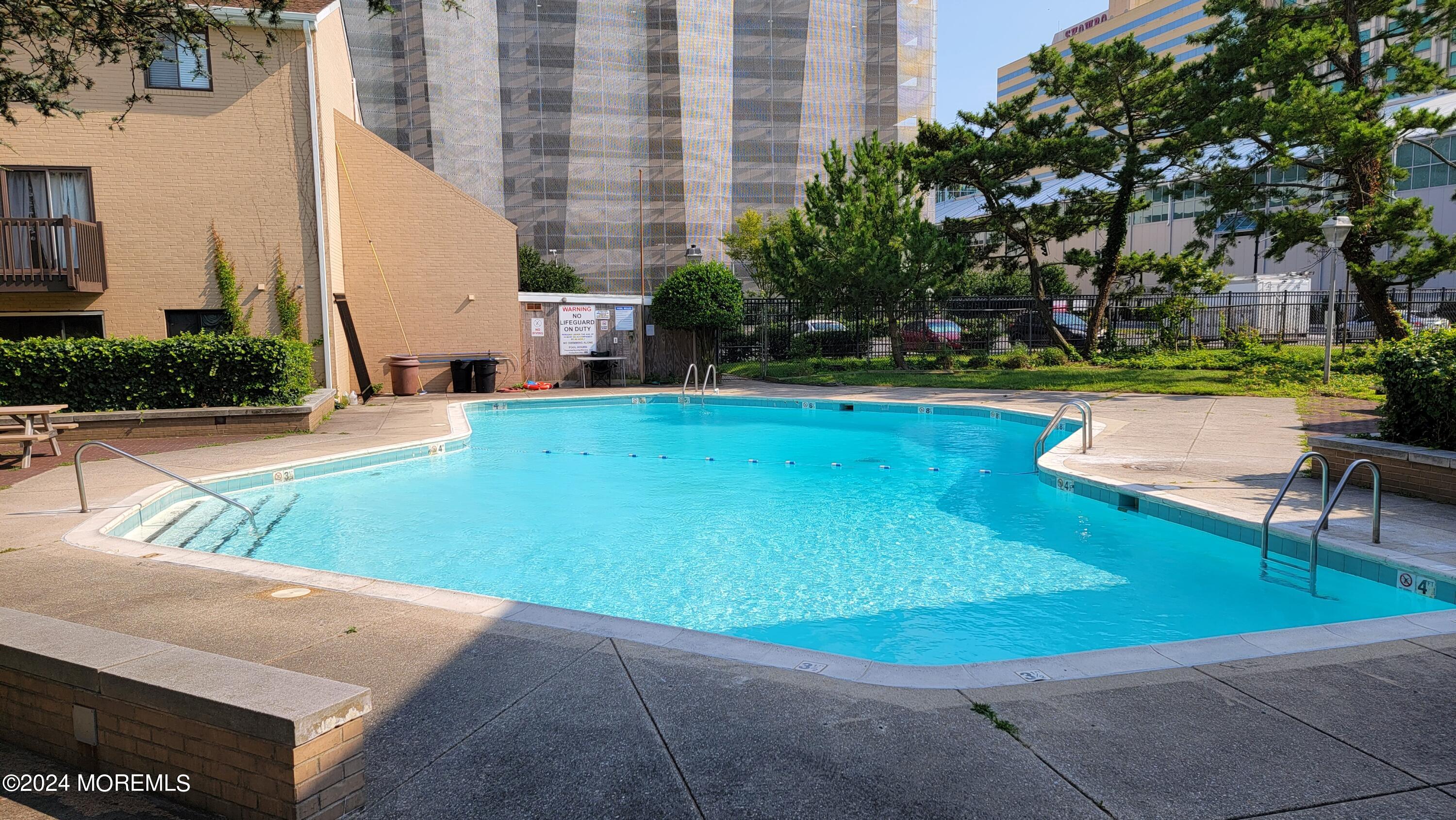 a view of backyard with swimming pool and seating area