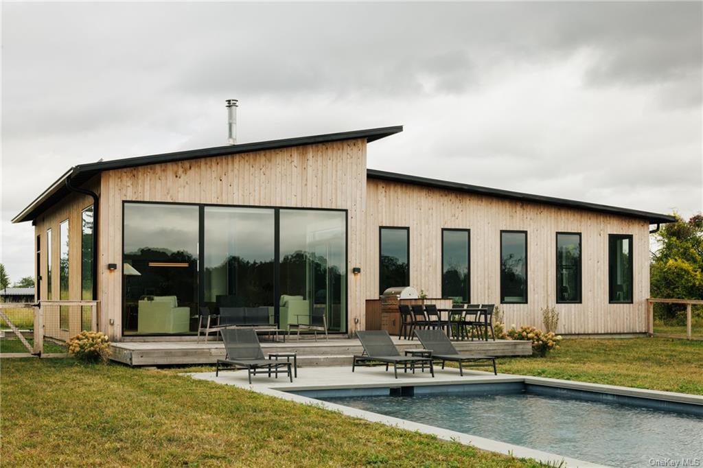 a view of a house with swimming pool and sitting area