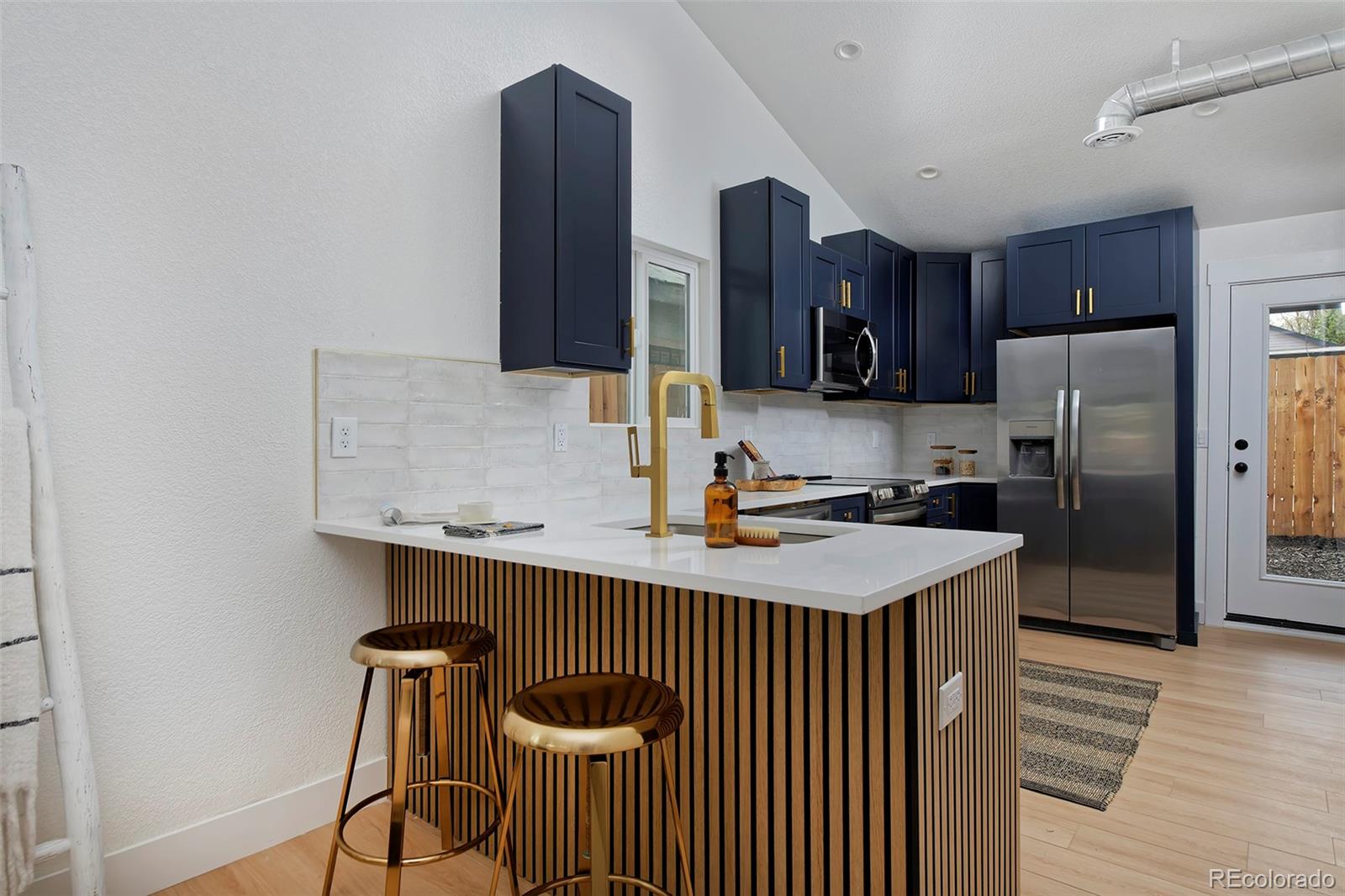 a kitchen with stainless steel appliances a sink and a refrigerator