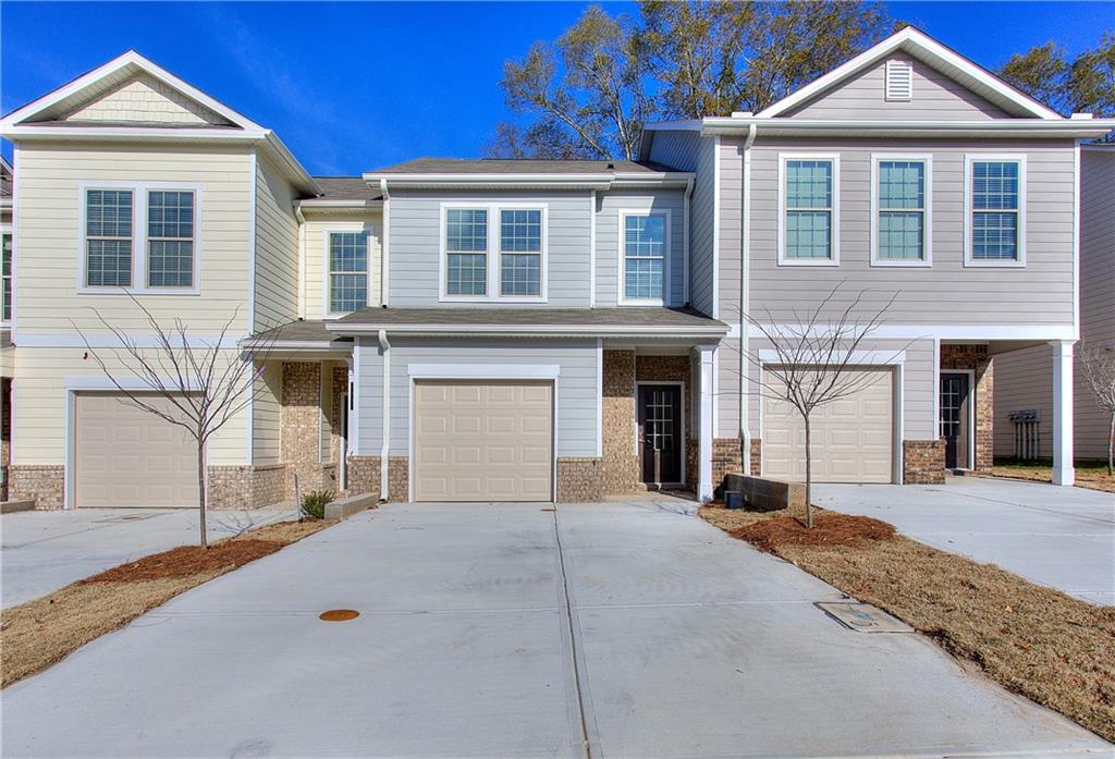 a front view of a house with yard and parking