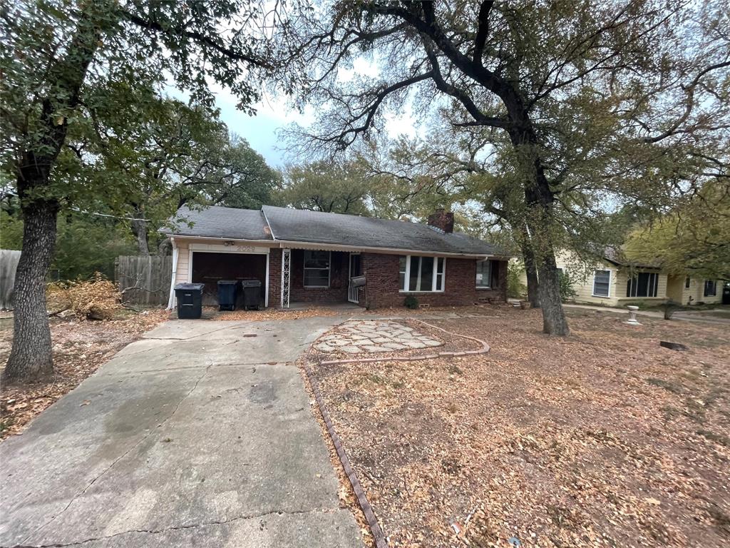 a front view of a house with a yard and trees