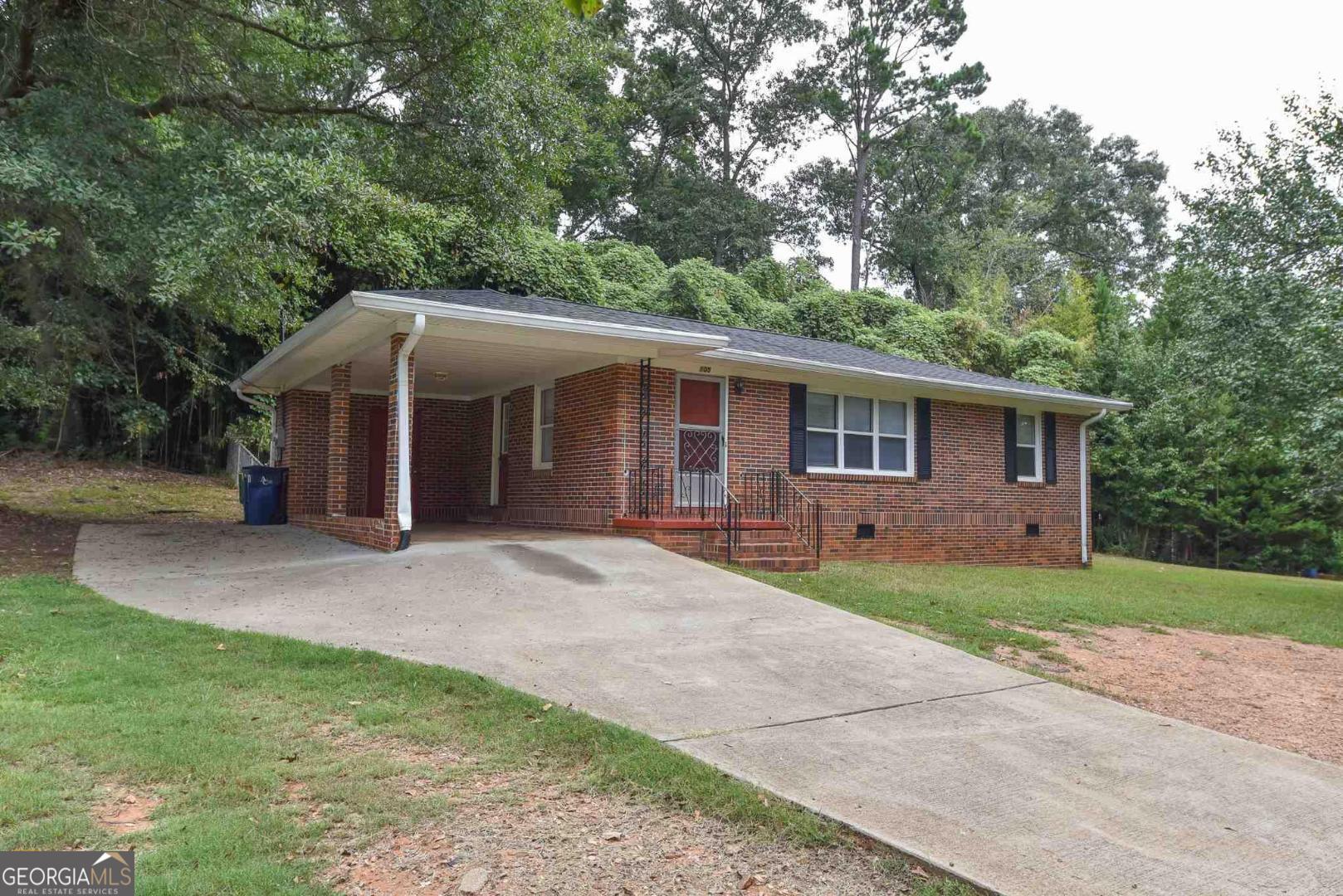 a front view of a house with a garden and yard