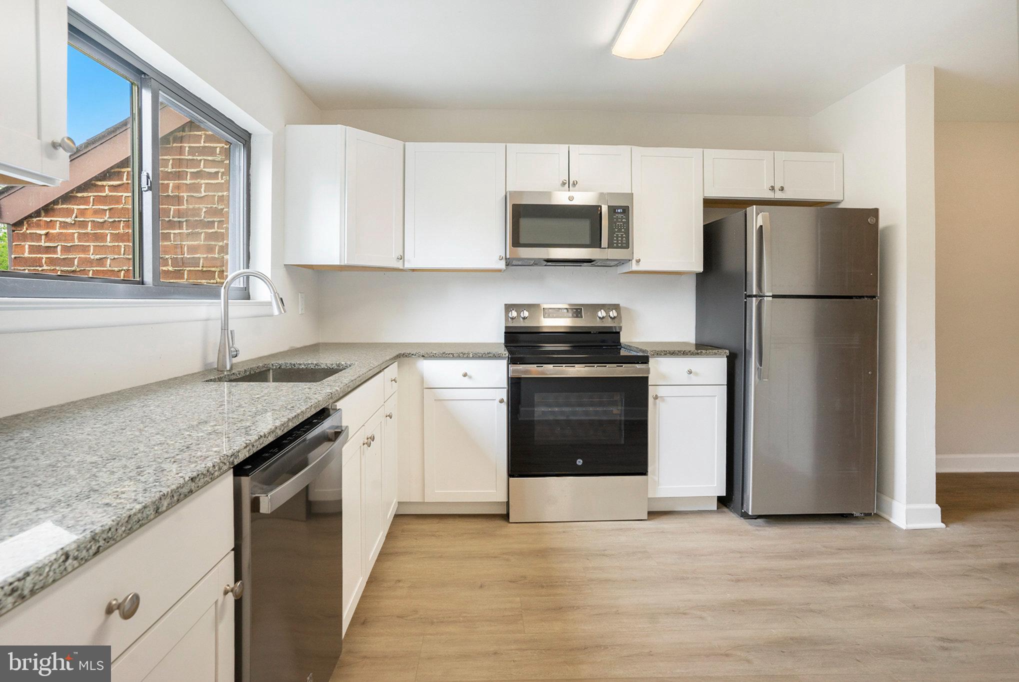 a kitchen with stainless steel appliances granite countertop a refrigerator sink and stove