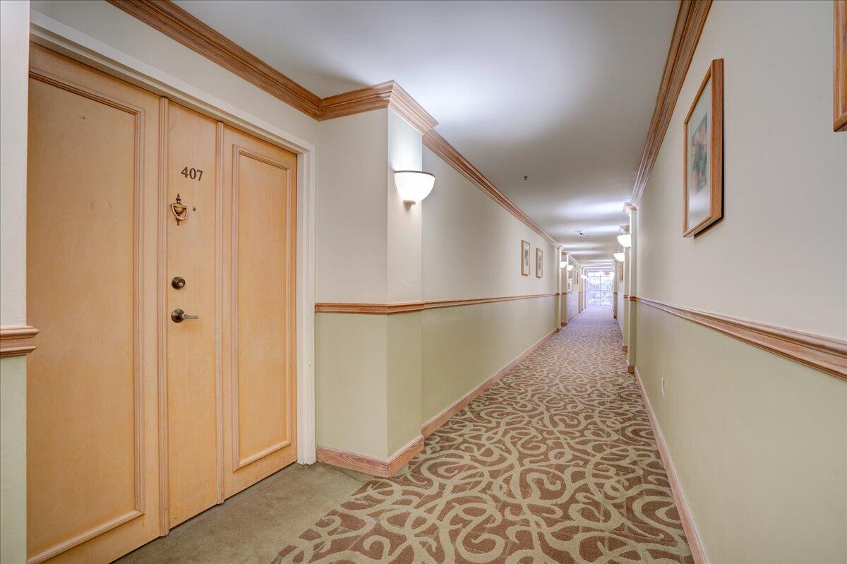 a view of a hallway with wooden floor and staircase