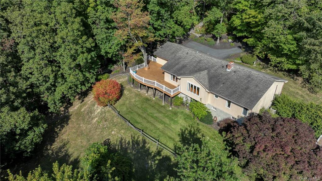 an aerial view of a house with a yard and large trees