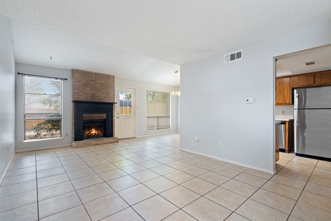 a view of an empty room with a fireplace and a window